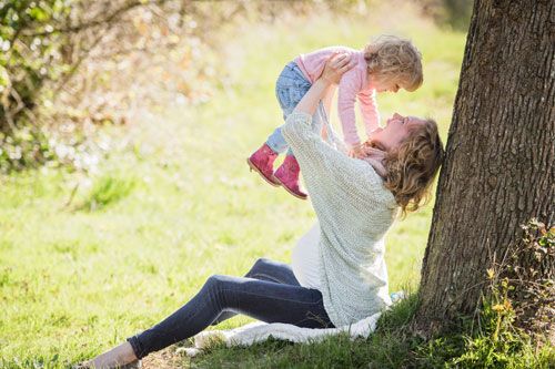 Schwangeres Mami, welches mit Kleinkind lacht